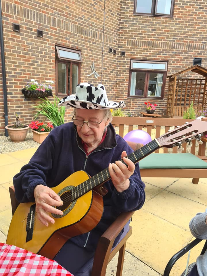 Catherine Court - resident playing with guitar 